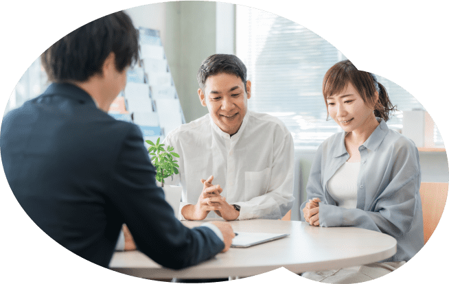 車椅子に座るシニア女性と笑顔で寄り添う介護士。花束を手渡す温かい場面