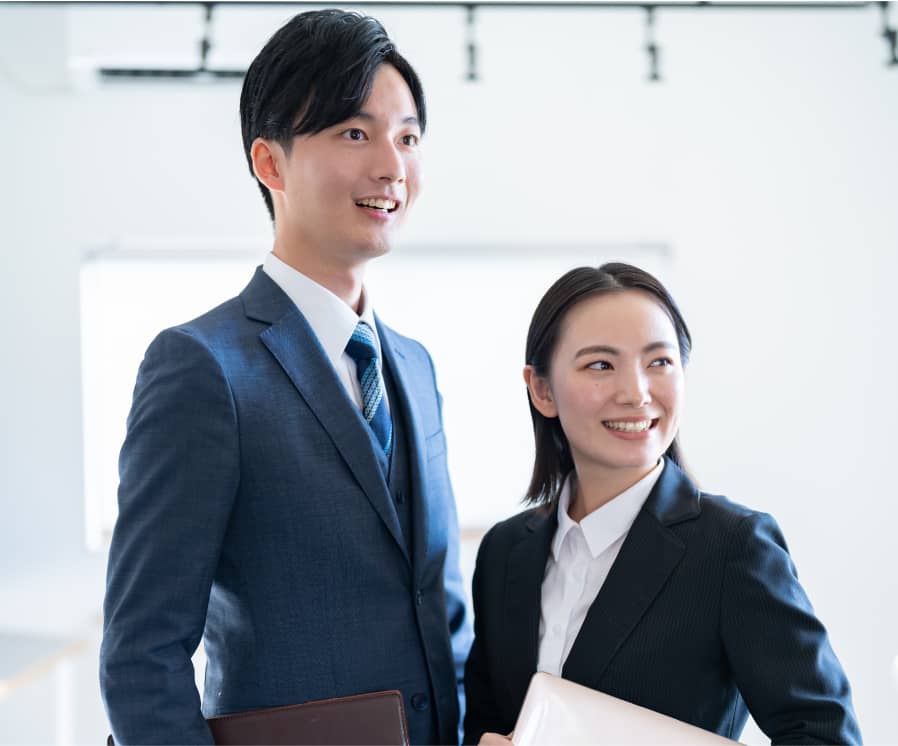 明るいオフィスで撮影された男女。彼らは自信に満ちた表情をしている